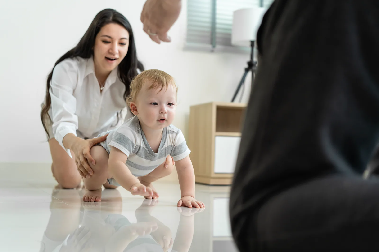 A parent crouched at a child's eye level, fully attentive, in soft daylight