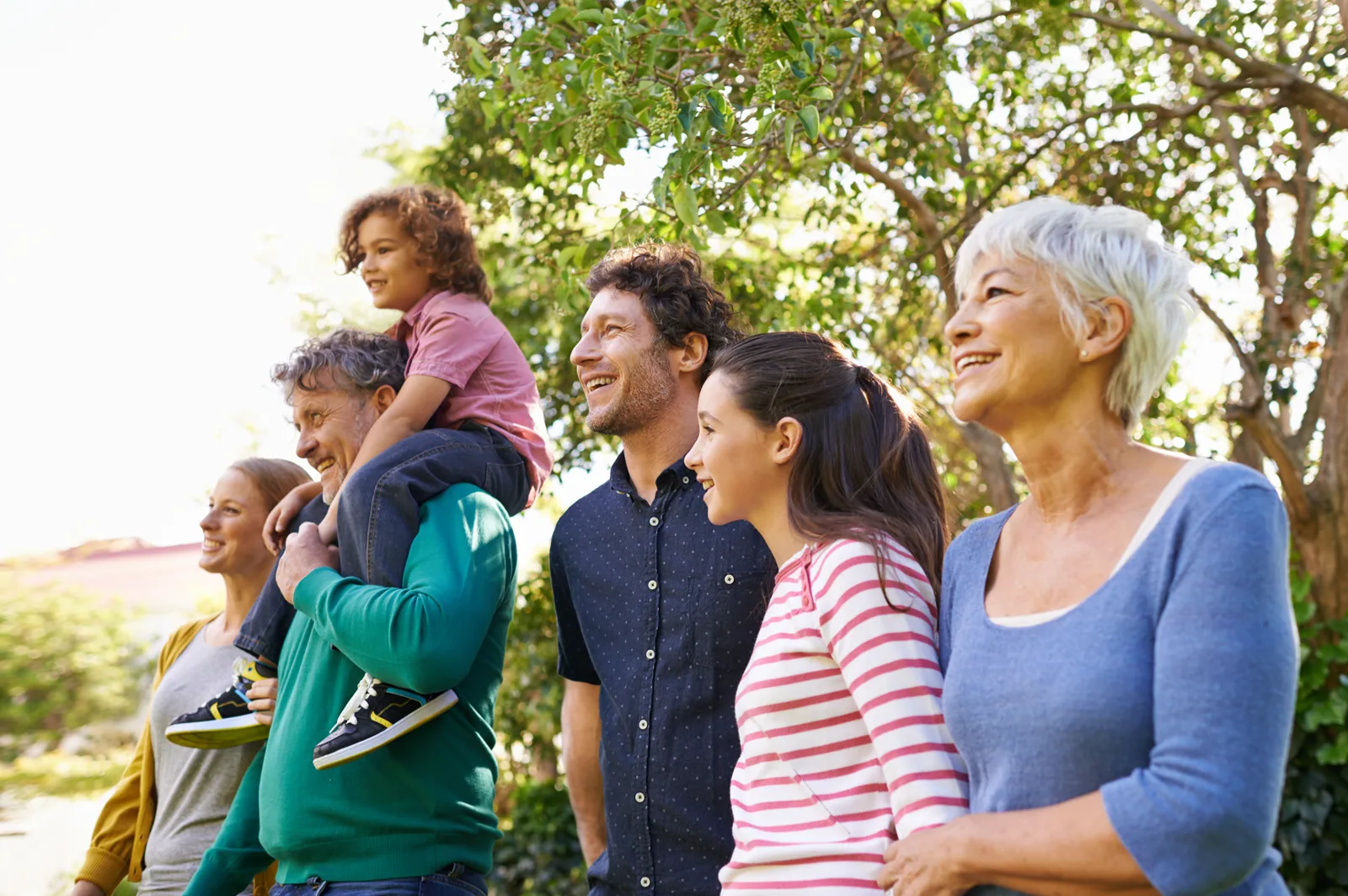 A family of different generations together outdoors in warm light